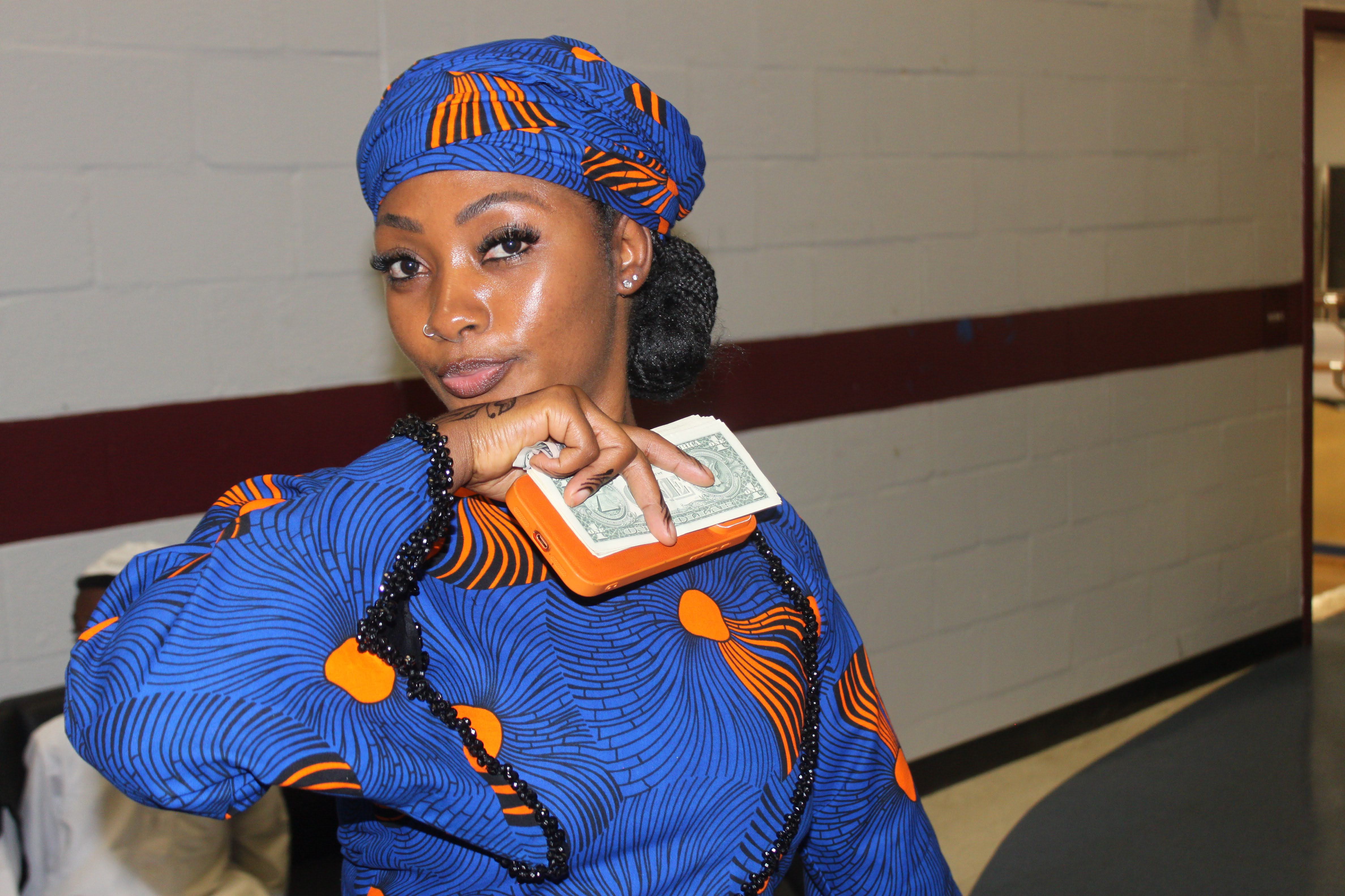 Ramatou in a blue and orange patterned dress and headwrap at a Fulani community event